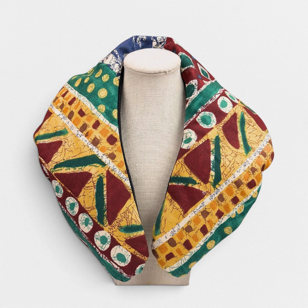 Handmade flaxseed neck wrap in golden yellow, green, and burgundy geometric fabric
